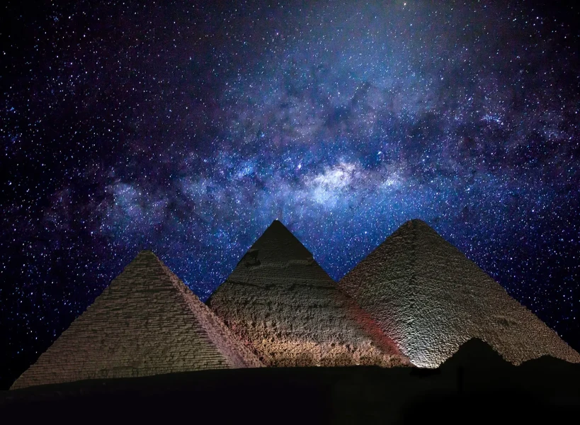 Pyramids of Giza illuminated under the night sky